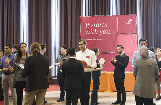 UIC Business student with PwC professionals at the UIC Business Career Fair