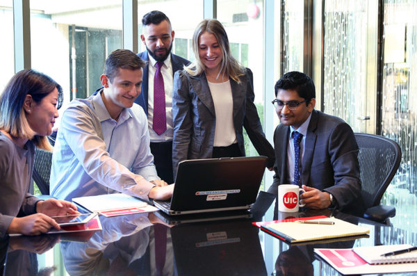 Group of business students in front of a laptop