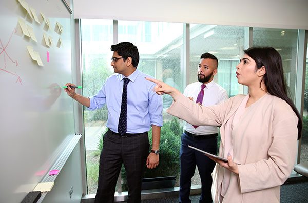 Business students work at a white board