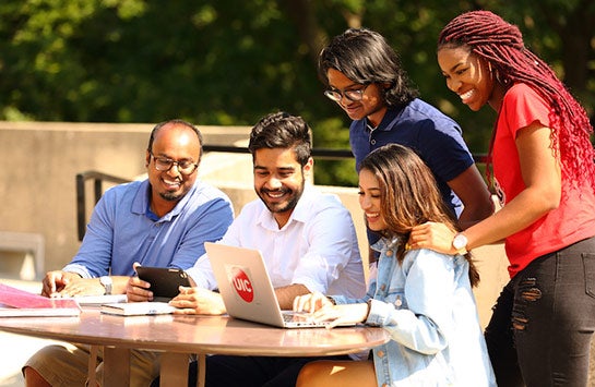 Group of UIC students crowded around a laptop