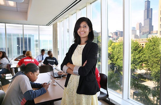 Female UIC student standing up and smiling while in class