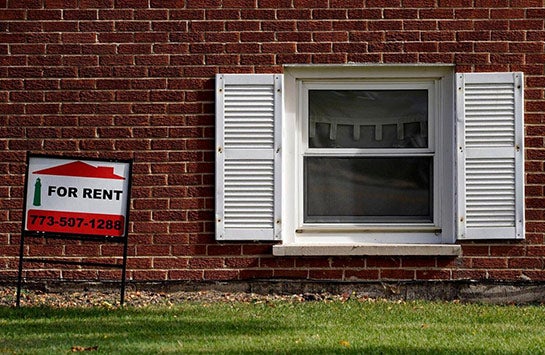 A ground-level home window with a for sale sign next to it