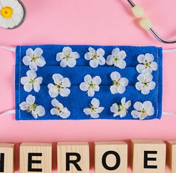 Stethoscope, flowers and medical protective mask with wooden cubes. Text heroes for gratitude to medical personnel and doctors 