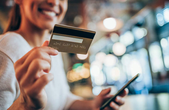 Person holding a smartphone and a credit card