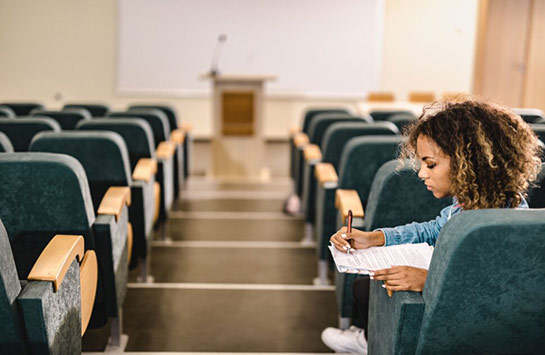 One student sitting in a lecture hall