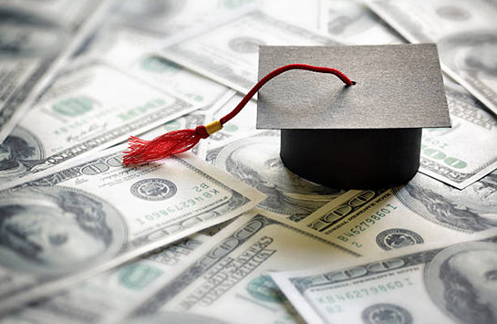 A graduation hat placed on top of money