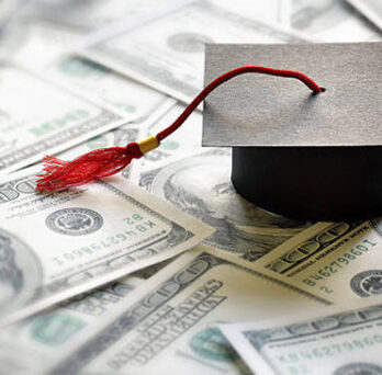 A graduation hat placed on top of money 
