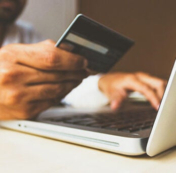 A person holding a credit card and making an online payment 
