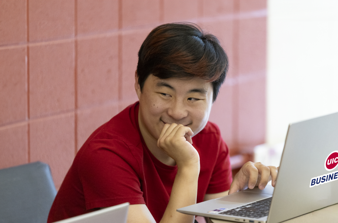 UIC Business MSSCOM student working on laptop.